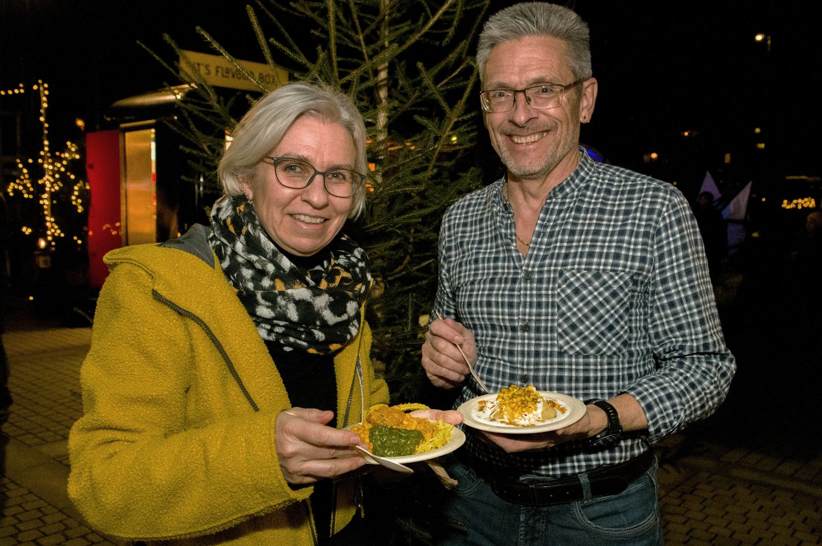 Menschen in winterlicher Kleidung beim Essen. 